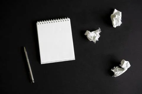 Flat lay of blank white notepad, pencil and crumpled paper on black backgroun Stock Photos