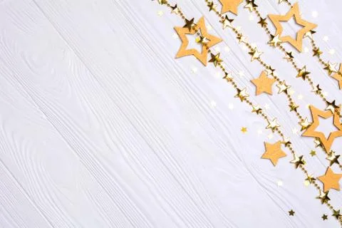 Flat lay border of big and small stars of confetti. Golden beads of shine sta Stock Photos