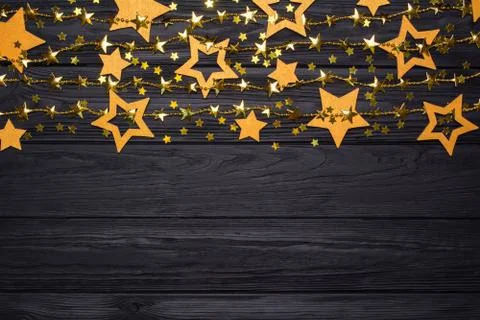 Flat lay border of big and small stars of confetti. Golden beads of stars. Stock Photos