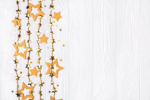 Flat lay border of big and small stars of confetti. Golden beads of shine sta Stock Photos