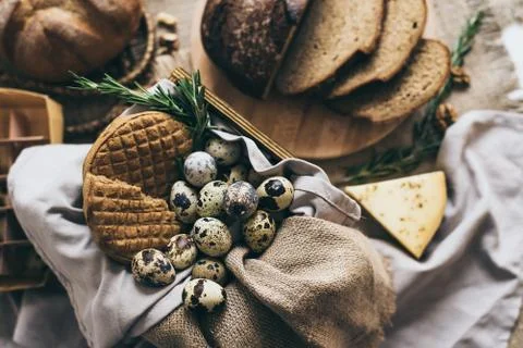 Flat lay of bread cake slices with quail eggs, herbs, cheese. Yellow cup of milk 스톡 사진
