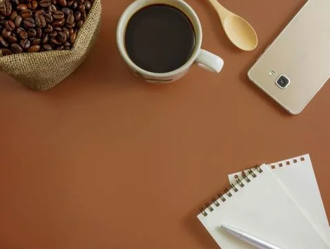 Flat lay brown desk with notebook,smart phone and coffee Stock Photos