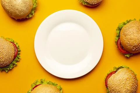 Flat lay burgers with empty plate Stock Photos