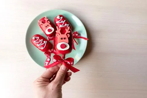 Flat lay of cake pops ice cream on a stick in red glaze with christmas picture Stock Photos