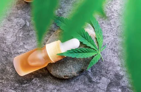 Flat lay of CBD or THC full spectrum medical Cannabis oil on stone table with Stock Photos