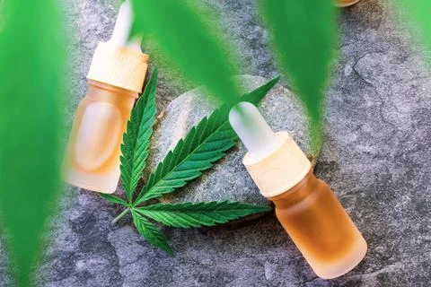 Flat lay of CBD or THC full spectrum medical Cannabis oils on stone table wit Stock Photos