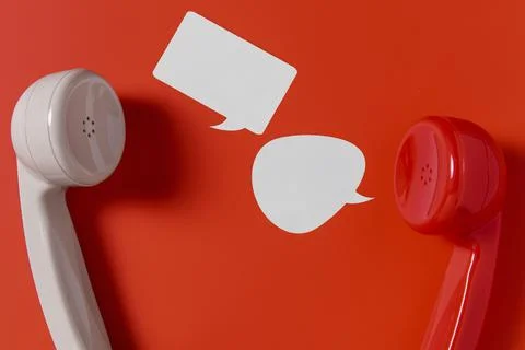 Flat lay chat bubbles with two telephone receivers Stock Photos