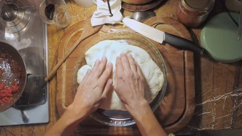 Flat lay of chef  kneading pizza dough in a metal container 動画素材 118209702