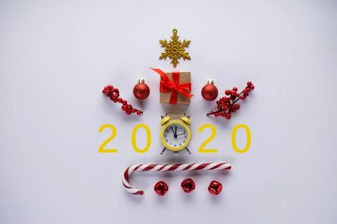 Flat lay of Christmas clock, candy, toys and numbers 2020 on gray background. Stock-Fotos