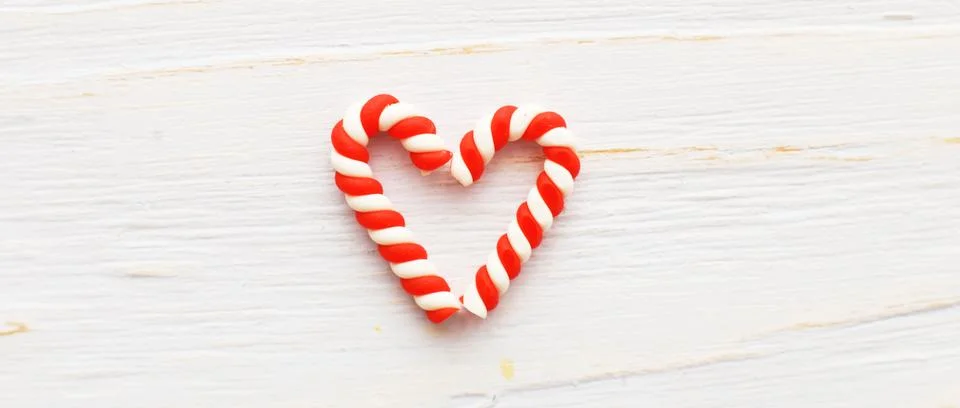 Flat lay Christmas composition with candy canes in the form oh heart on a lig 스톡 사진