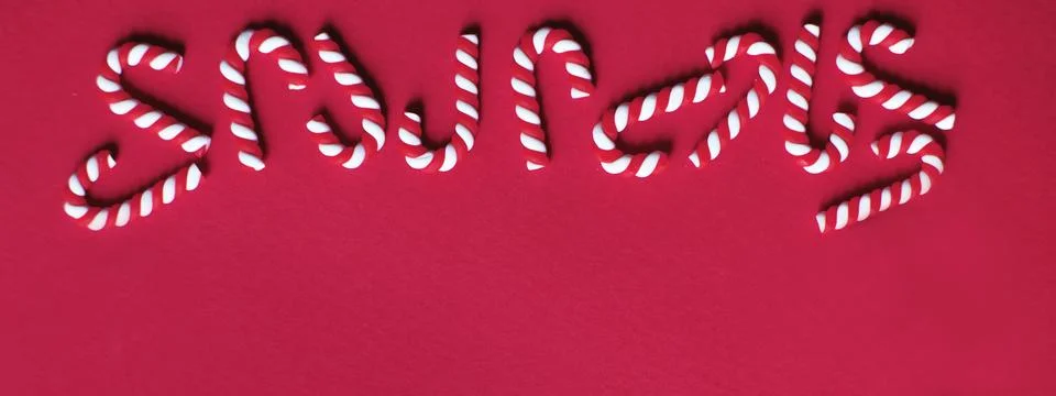 Flat lay Christmas composition with frame of candy canes on a red background. Fotos Stock