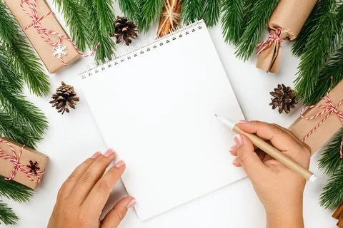 Flat lay Christmas frame with decorations, woman hands write letter to Santa Stock Photos