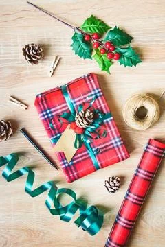 Flat lay of a Christmas gift box wrapped in scottish tartan pattern paper w.. Stock Photos