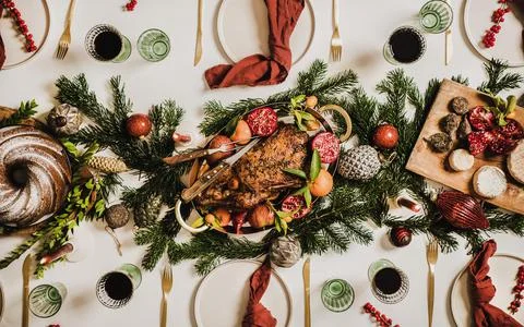Flat-lay of Christmas table setting with chicken, wine and decorations Stock Photos