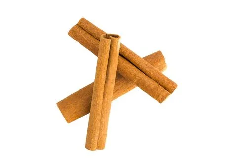 Flat lay of cinnamon bark shards on white, emphasizing their organic forms .. Stock Photos