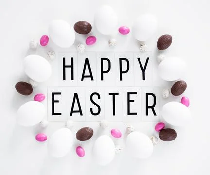 Flat lay close up of happy Easter text, eggs and sweets over white Fotos Stock
