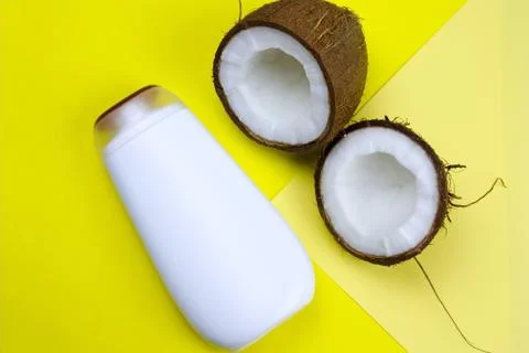 Flat lay coconut and mock upwhite  plastic  bottle  on a yellow background Stock Photos