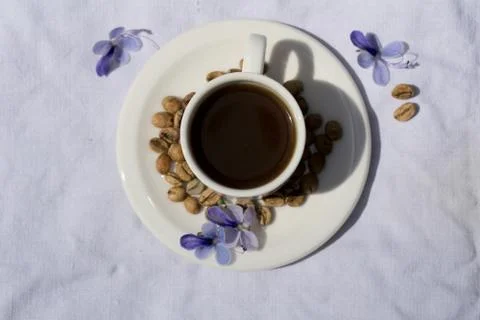 Flat lay Coffee composition  with  white cup  and beans of coffe and blue flo Stock Photos