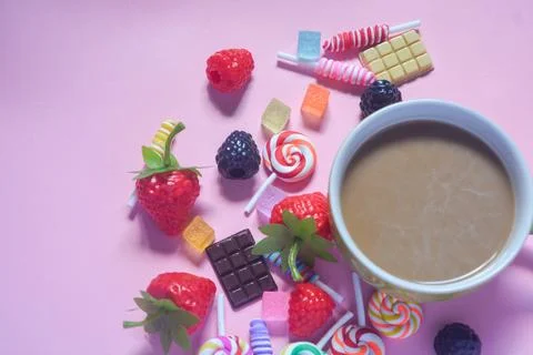 Flat lay coffee mug with chocolate bar, cotton candy and candy ornaments Stock Photos