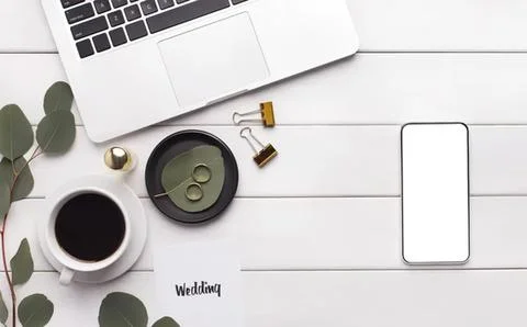Flat lay of coffee mug, phone, and wedding paper on desk Stock Photos