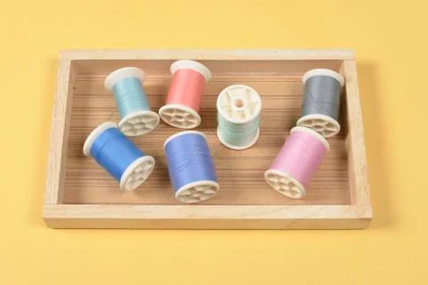 Flat lay of colored thread rolls for sewing on yellow background, Sewing and  Stock Photos