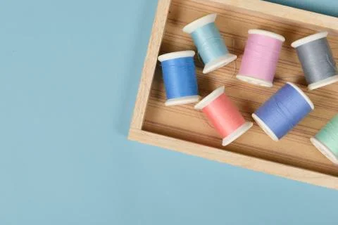 Flat lay of colored thread rolls for sewing on blue background, Sewing and ne Stock Photos
