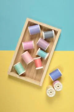 Flat lay of colored thread rolls for sewing on two tone background, Sewing an Stock Photos