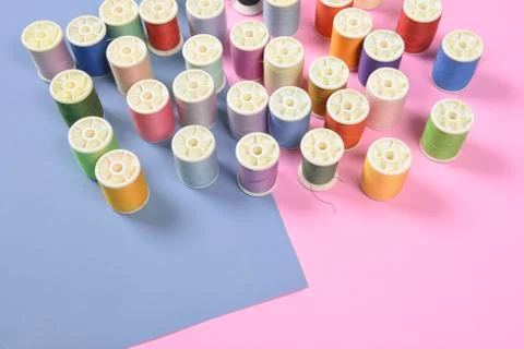 Flat lay of colored thread rolls for sewing on two tone background, Sewing an Stock Photos