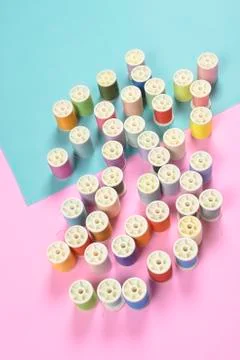 Flat lay of colored thread rolls for sewing on two tone background, Sewing an Stock Photos