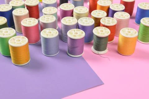 Flat lay of colored thread rolls for sewing on two tone background, Sewing an Stock Photos