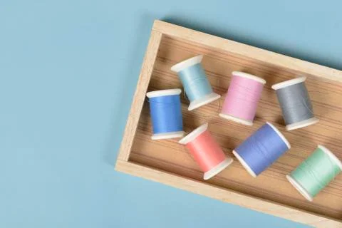 Flat lay of colored thread rolls for sewing on blue background, Sewing and ne Stock Photos