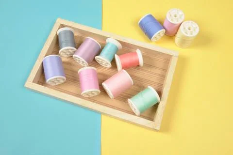 Flat lay of colored thread rolls for sewing on two tone background, Sewing an Stock Photos