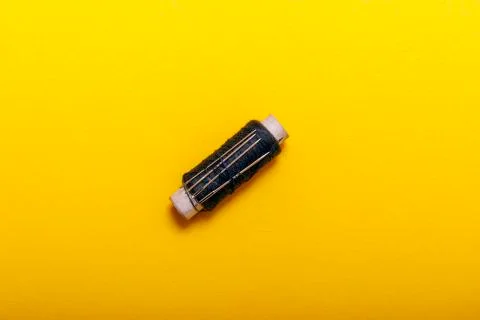 Flat lay of colored thread rolls and Scissors for sewing yellow background. S Stock Photos