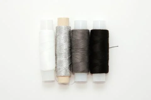 Flat lay colorful cotton thread spools, embroidery white, gray, black, silver Fotos de archivo