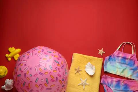 Flat lay composition with ball and beach objects on red background, space for 写真素材