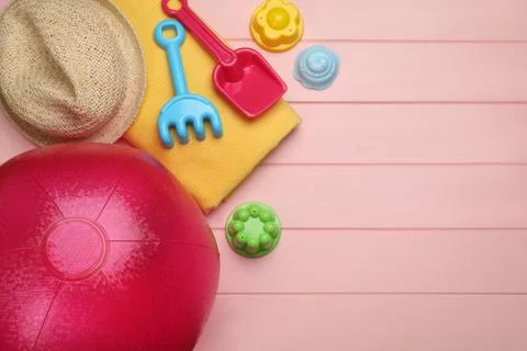 Flat lay composition with beach ball and sand toys on pink wooden background. 写真素材