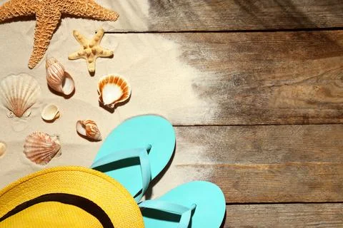 Flat lay composition with beach objects, sand and space for text on wooden ba Stock Photos
