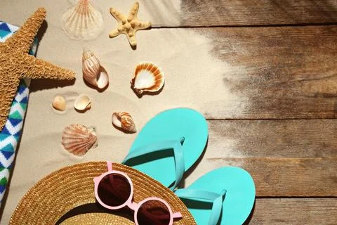Flat lay composition with beach objects, sand and space for text on wooden ba 스톡 사진