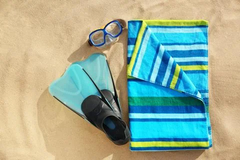 Flat lay composition of beach objects and towel on sand Stock Photos