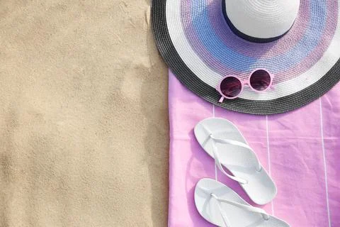 Flat lay composition of beach objects and towel on sand, space for text 스톡 사진