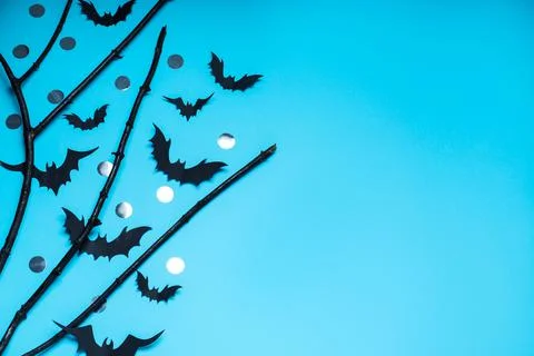 Flat lay composition with black branches and paper bats on light blue backgro Stock Photos