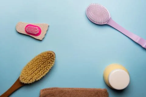 Flat lay composition with body dry brush and towel on blue background Stock Photos