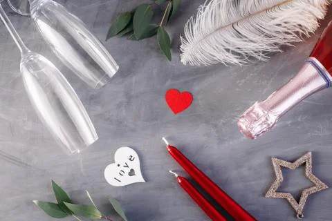 Flat lay composition with bottle of champagne, candles, feather and hearts fo Stock Photos