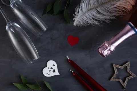 Flat lay composition with bottle of champagne, candles, feather and hearts fo Stock Photos