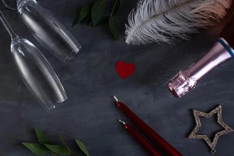 Flat lay composition with bottle of champagne, candles, feather and hearts fo Stock Photos