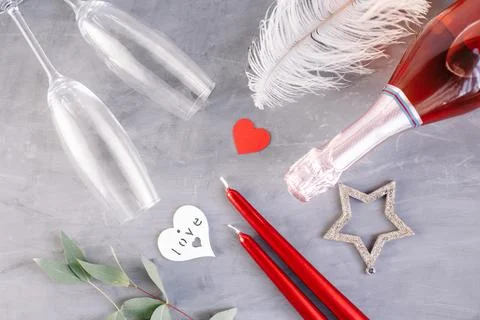 Flat lay composition with bottle of champagne, candles, feather and hearts .. Stock Photos
