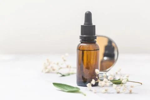 Flat lay composition with bottle of natural essential oil on white marble Stock Photos