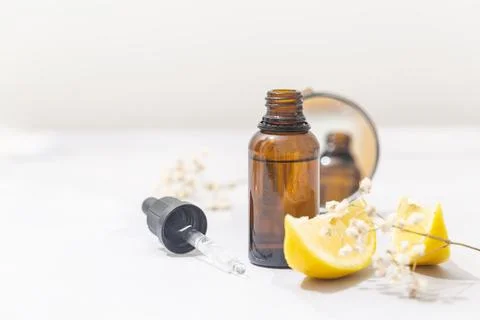 Flat lay composition with bottle of natural essential oil on white marble Stock Photos