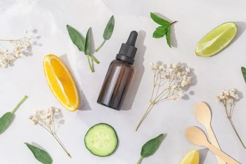 Flat lay composition with bottle of natural essential oil on white marble Stock Photos