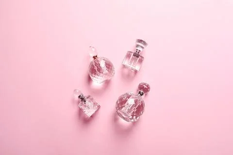 Flat lay composition with bottles of perfume on pink background Stock-Fotos